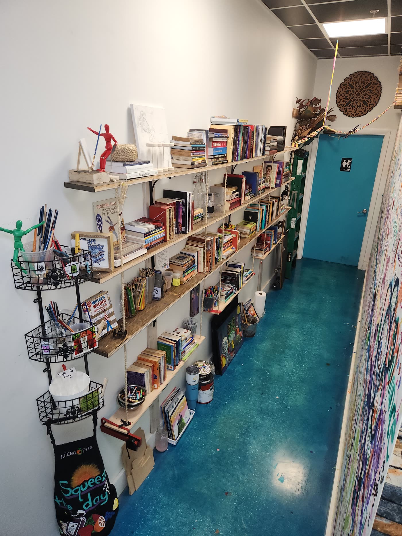 The community library shelves inside Swami Juice, in the hallway next to the Wishing Wall